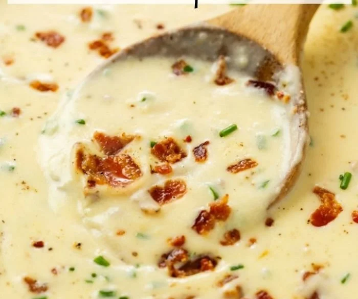 Bowl of creamy baked potato soup topped with cheese and green onions.