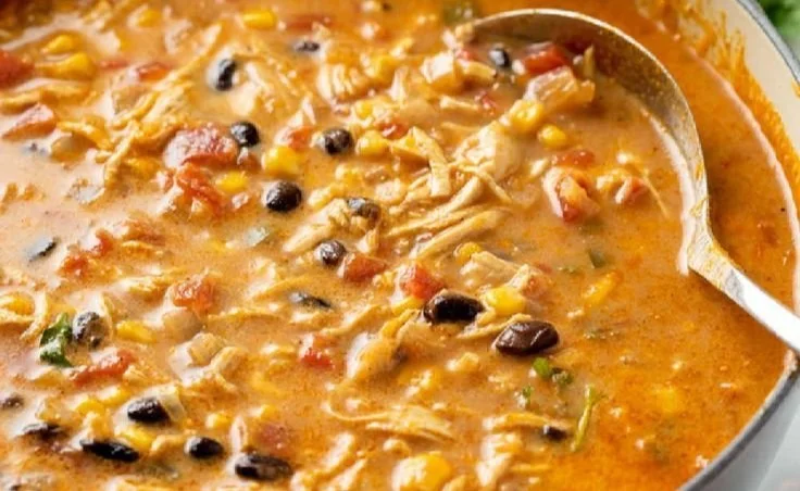 Creamy chicken tortilla soup with tortilla strips and garnishes