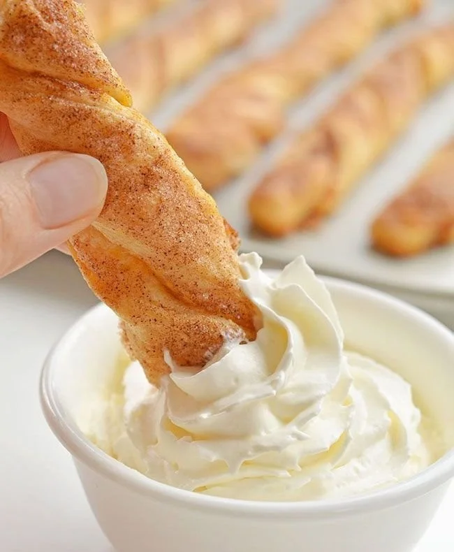 Easy pumpkin pie twists served on a plate with whipped cream topping