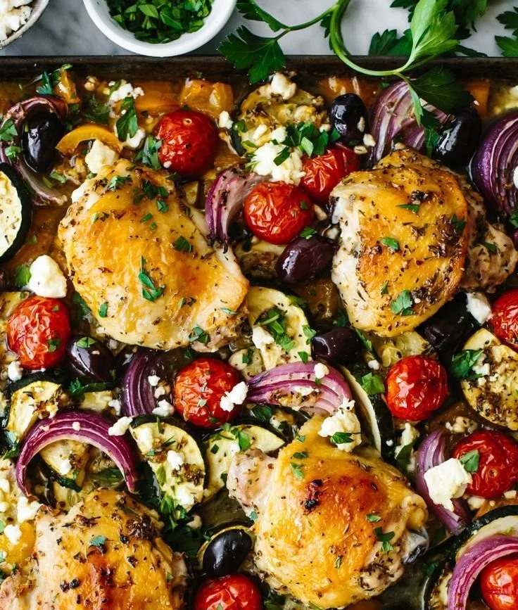 Delicious Greek Sheet Pan Chicken served with colorful veggies on a baking tray.