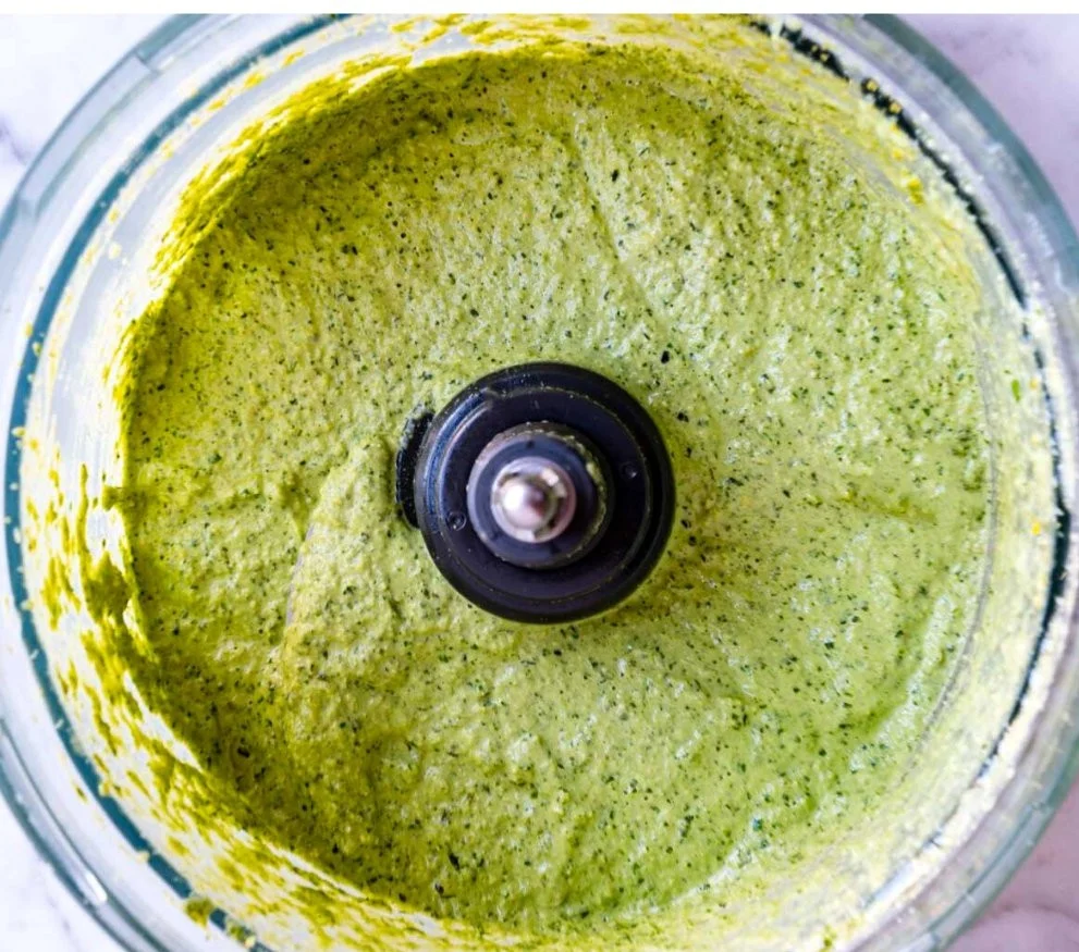 Nut-free pumpkin seed pesto in a bowl with fresh basil and ingredients