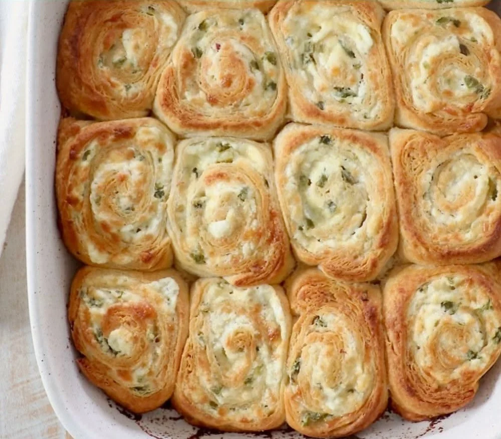 Spicy jalapeno popper crescent rolls on a plate garnished with herbs