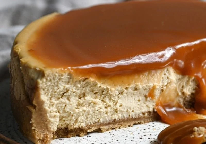 Delicious slice of Apple Cider Cheesecake topped with caramel and apple slices