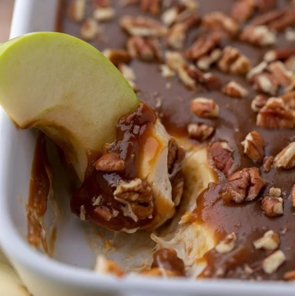 Delicious caramel apple cheesecake dip served with apple slices.