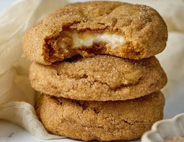 Chewy pumpkin cheesecake cookies fresh out of the oven, garnished with spices.