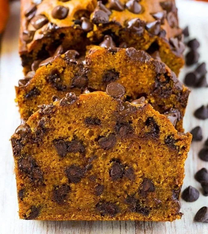 Slice of chocolate chip pumpkin bread on a wooden table