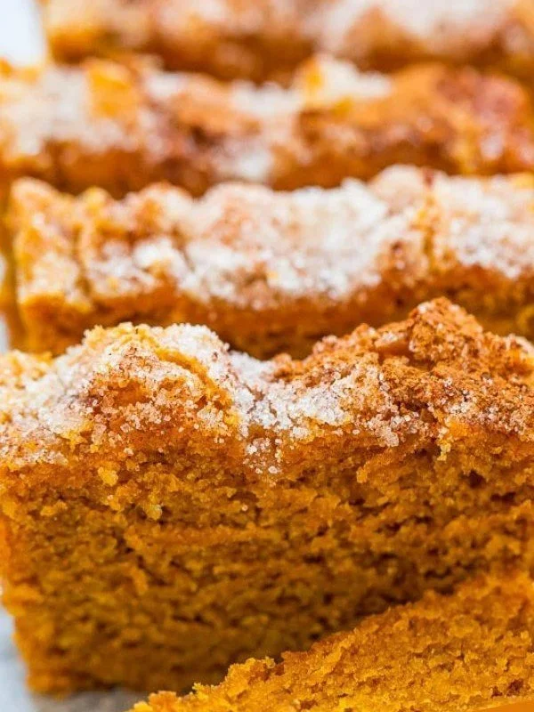 Freshly baked cinnamon sugar pumpkin bread loaf on a rustic wooden table