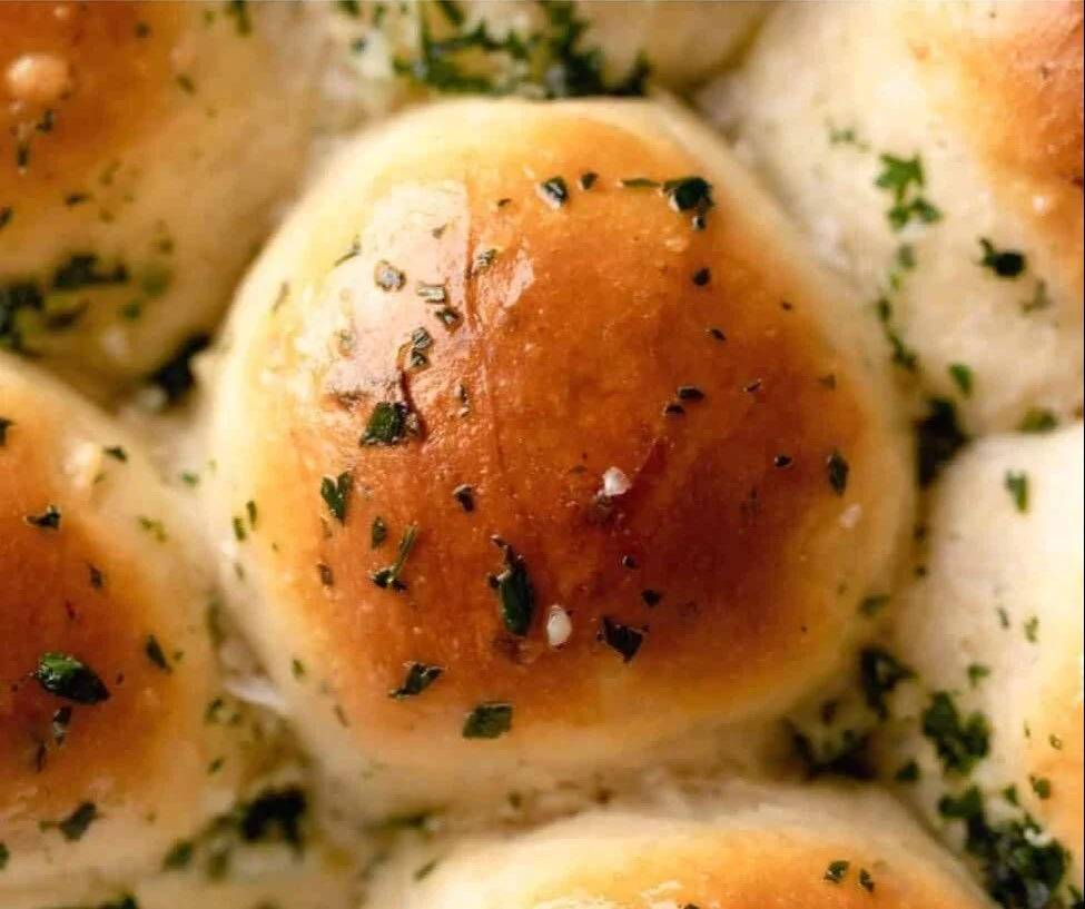 Freshly baked garlic butter bread rolls on a wooden table