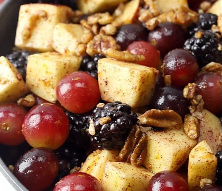 Fall fruit salad with cinnamon orange dressing in a colorful serving bowl