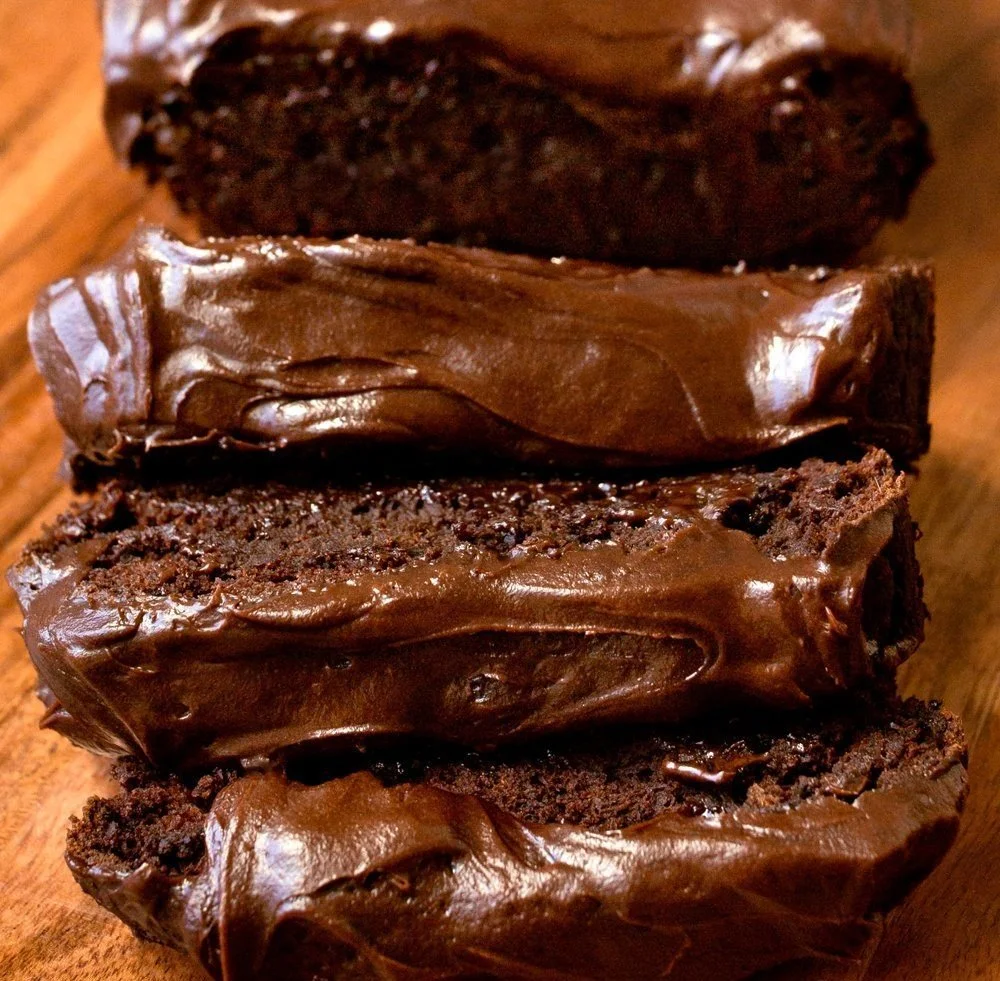 Frosted dark chocolate pumpkin bread served on a wooden table