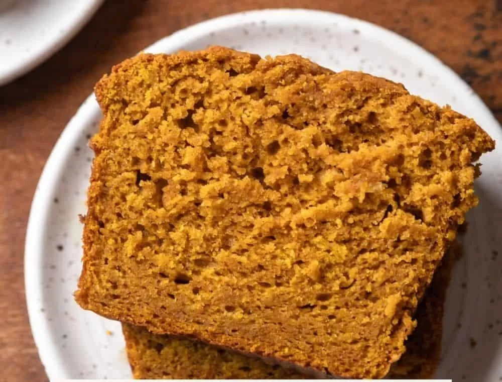 Delicious homemade pumpkin bread topped with a sprinkle of nuts and spices