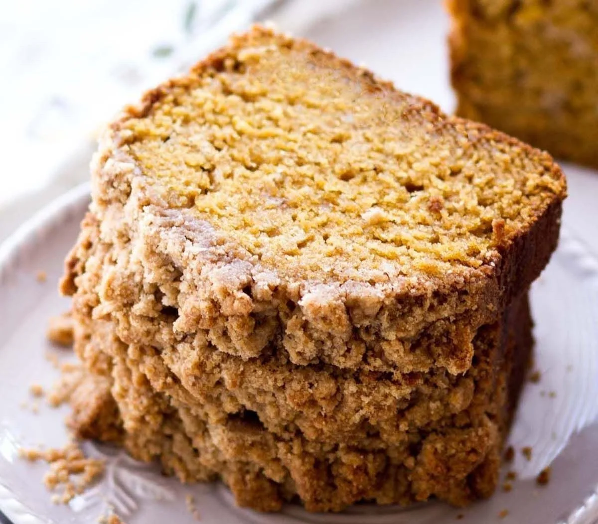 Delicious pumpkin bread with a golden crumb topping on a wooden table