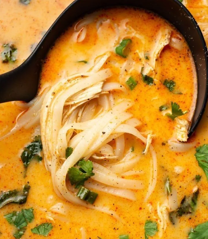 Delicious bowl of Thai Chicken Soup with fresh herbs and spices.