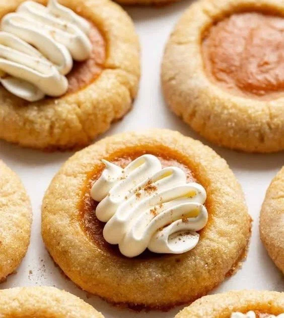 Thick and chewy pumpkin pie cookies topped with pumpkin spice and served on a plate.